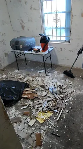 Renovation debris, a bucket and bags in a room being redone
