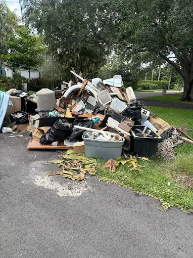 Bags, a chair and household trash heaped on the grass