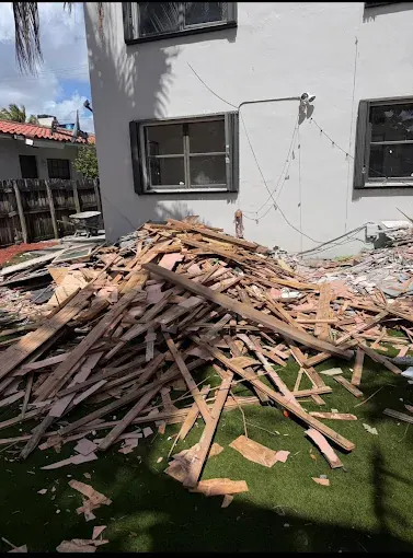 Loose lumber and wood scraps piled beside a house